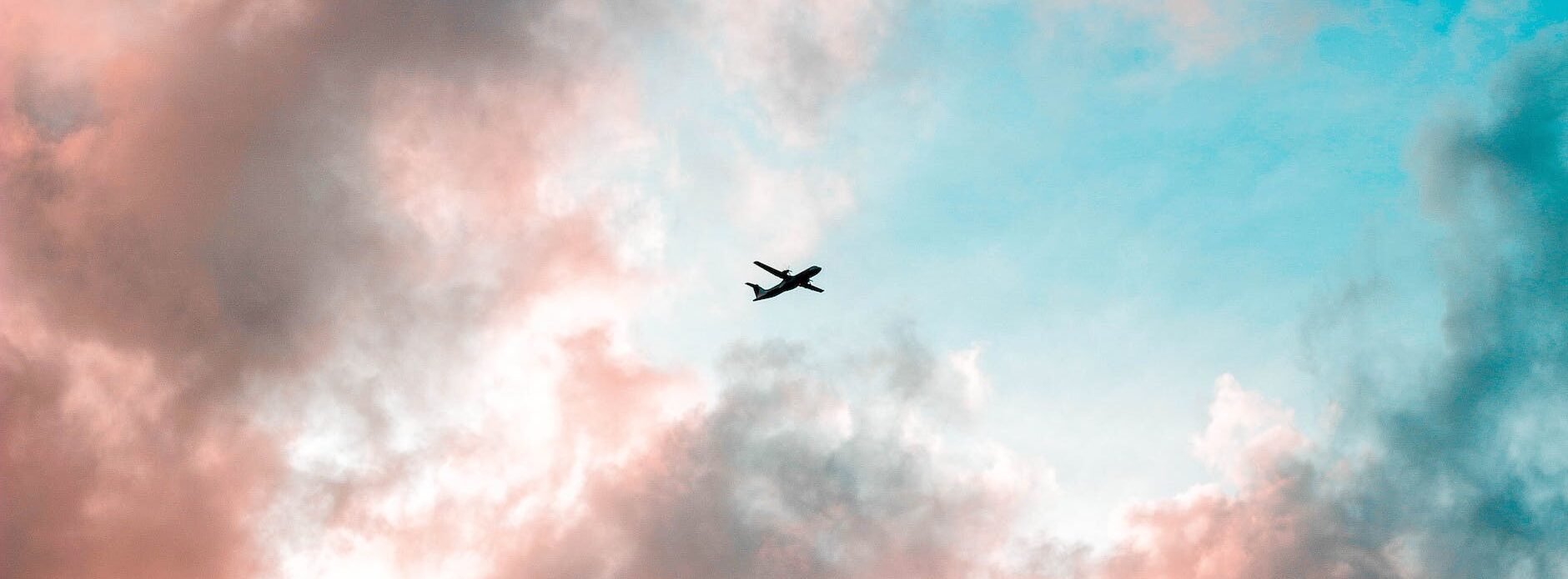 silhouette of airplane under cloudy sky